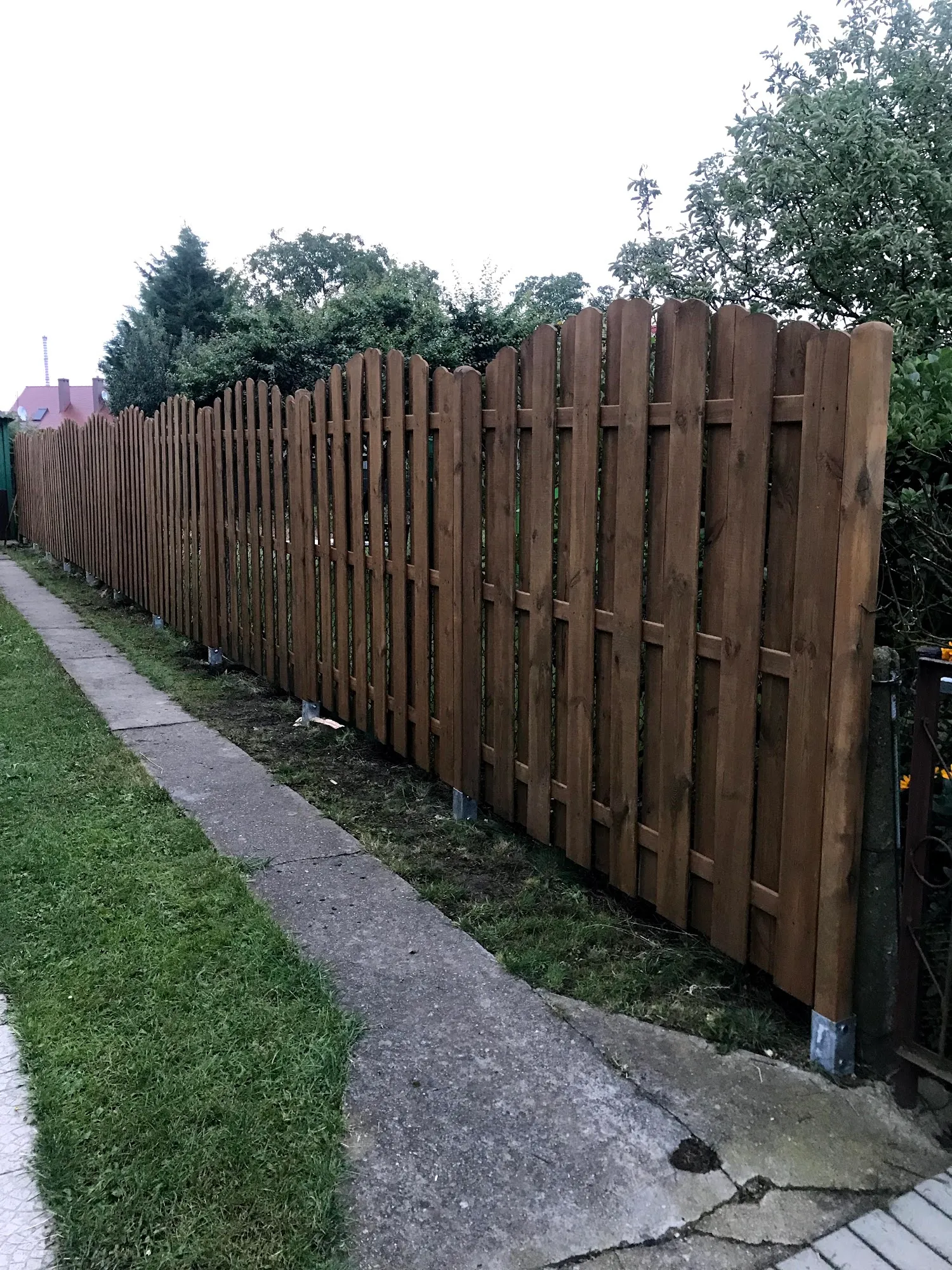Montierter Gartenzaun aus Holz am Gehweg